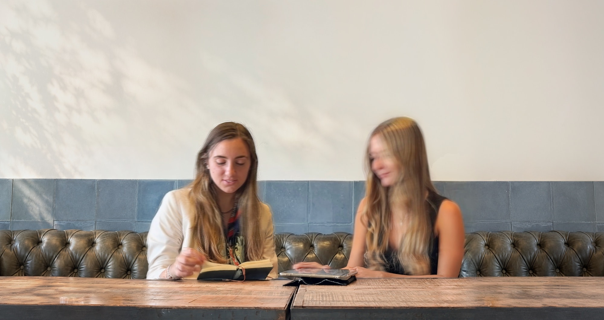 Catalina y Pilar, socias de cup arq, trabajando en una mesa de madera.